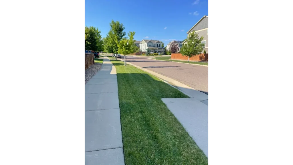 Residential lawn care curb appeal with straight sidewalk mow lines from Great Plains Home Services.