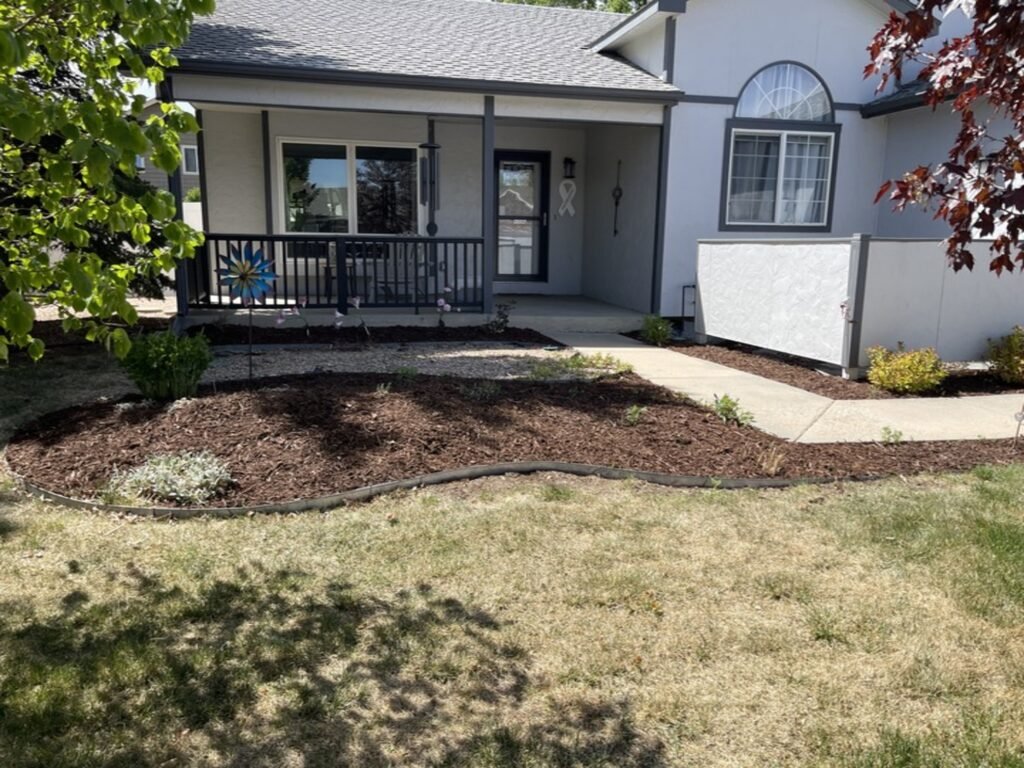 Professional mulch installation and flower bed edging for a residential home in Windsor, Colorado.