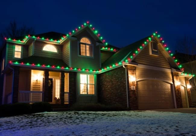 Professional Christmas light installation using classic alternating red and green lights along the roofline and gables of a two-story house in Northern Colorado.