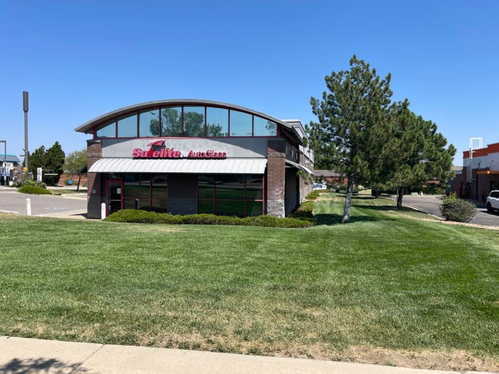 Professionally mowed and striped commercial lawn and exterior property maintenance at Safelite AutoGlass in Northern Colorado.
