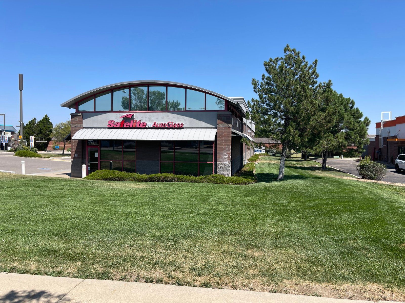 Professionally mowed and striped commercial lawn and exterior property maintenance at Safelite AutoGlass in Northern Colorado.